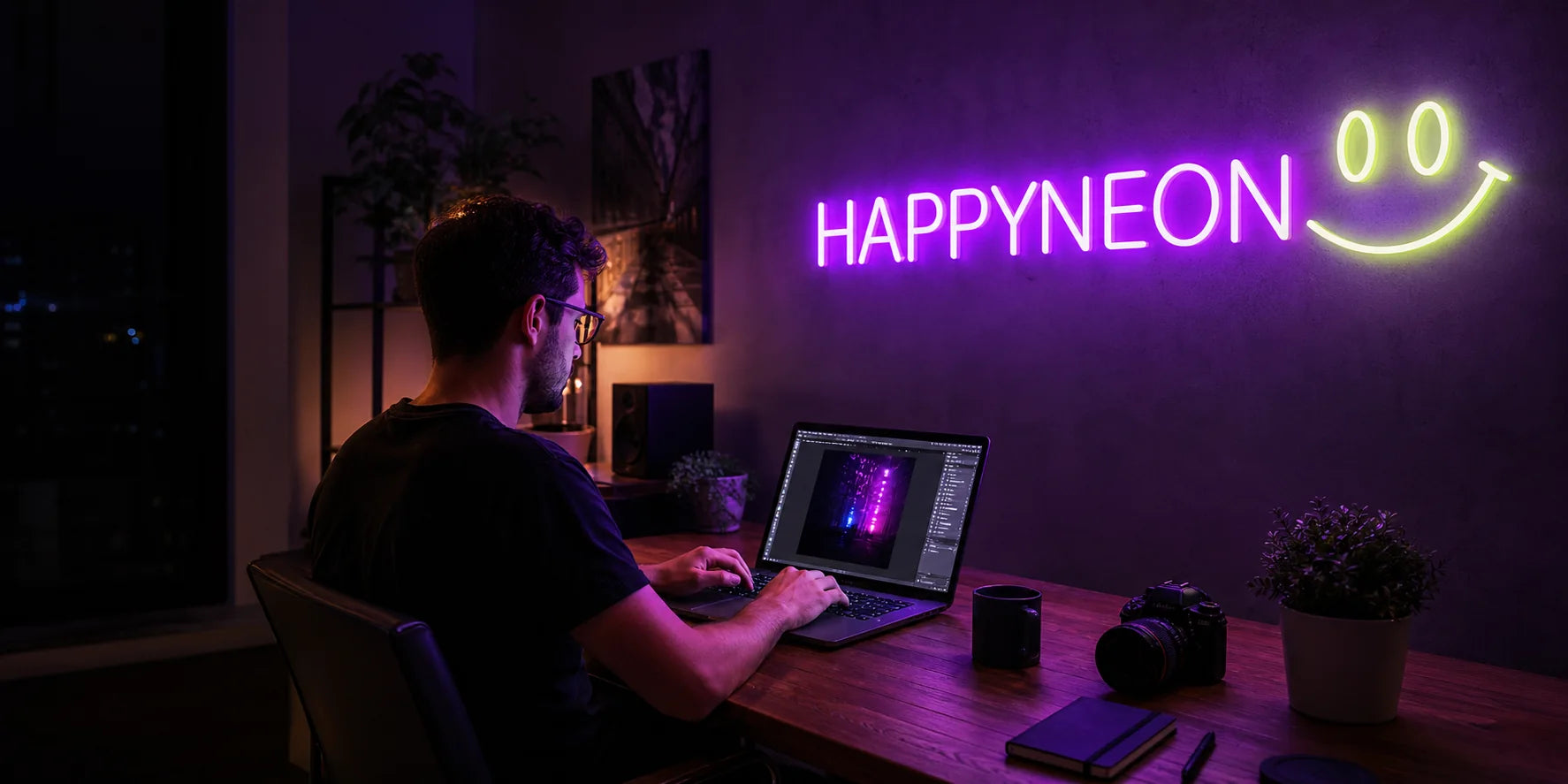 Ein Gestalter bei der Arbeit unter einem leuchtenden HAPPYNEON Logo